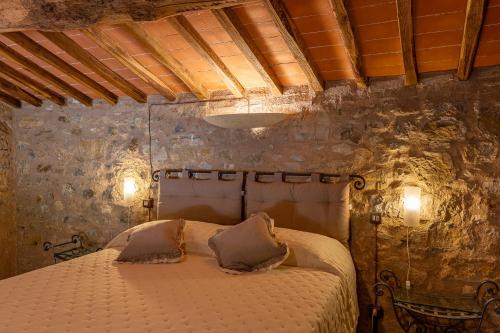 a bedroom with a bed in a stone wall at Borgo Pietraio Casa Vacanze in Radicondoli