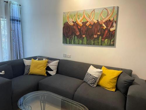 a living room with a couch and a painting on the wall at kariku house in Kigali