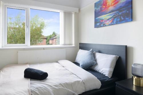 Un dormitorio con una cama blanca con una ventana. en Deleted, en Nottingham