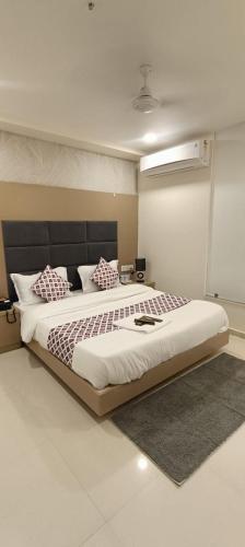 a bedroom with a large bed with pillows on it at Hotel Royal Square in Gandhinagar