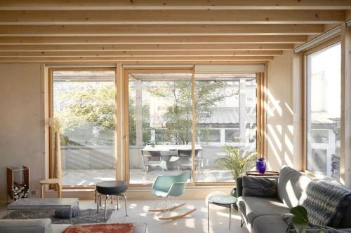un salon avec un canapé et une grande fenêtre dans l'établissement Maison d'architecte à 7 minutes en train de Paris, à Clamart