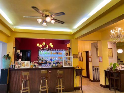 a bar in a restaurant with a ceiling fan at Sourire at Rattanakosin Island Hotel in Bangkok