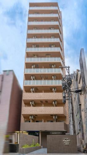 a tall building with many windows in a city at Apartment Hotel 11 Shinsaibashi 2 in Osaka