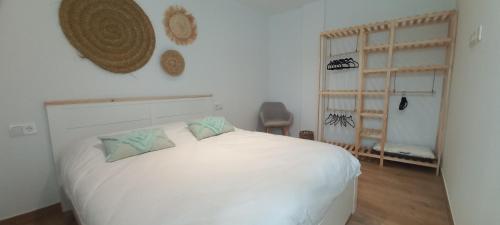 a bedroom with a white bed with two pillows at La familia Apartaments Mijas Pueblo in Mijas