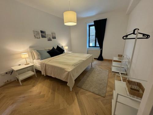 a white bedroom with a bed and a window at Heart of Klosterneuburg in Klosterneuburg