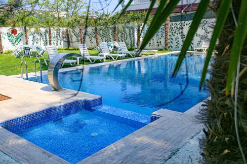 a swimming pool with chairs in a yard at Green Moringa Termal Hotel in Termal