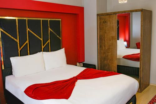 a bedroom with a large bed with a red wall at Green Moringa Termal Hotel in Termal