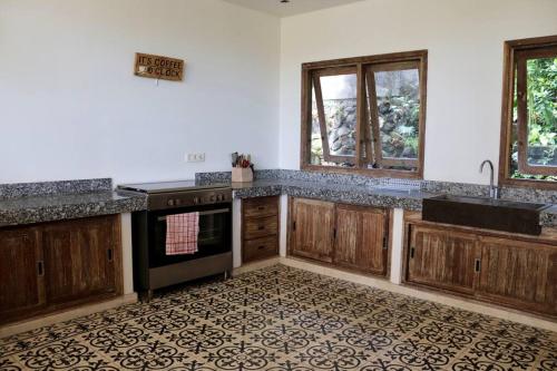 a kitchen with wooden cabinets and a stove top oven at Villa Masna Spacious 4 bdr in Canggu in Denpasar