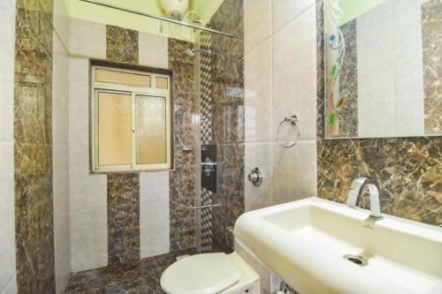 ein Badezimmer mit Waschbecken, Toilette und Dusche in der Unterkunft 4BHK VERONICA VILLA by Welcome Stays in Lonavla