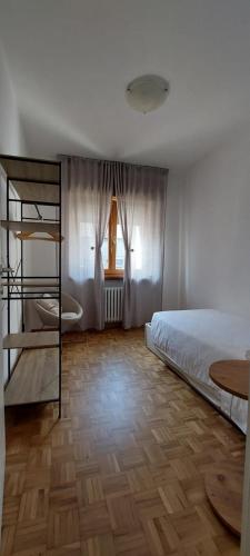 a bedroom with a bed and a wooden floor at Casa Elena in Pieve di Cadore