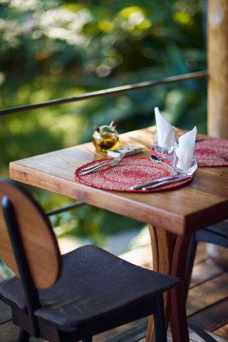 a wooden table with a napkin and fork and knife at Loharano Lodge in Ambaro