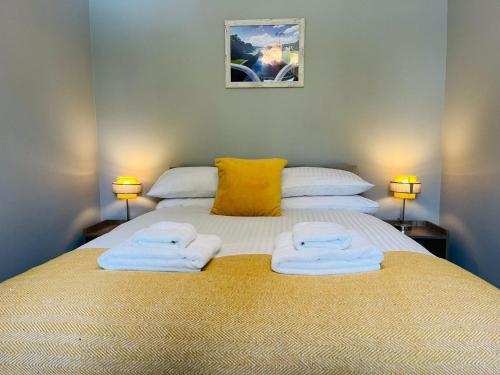 een slaapkamer met een bed met handdoeken erop bij Marina Apartments 3 in Fort William