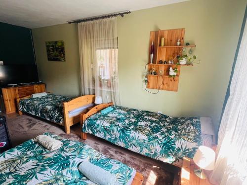 a room with two beds and a table at Arany Vendégház in Szarvas