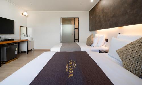 a hotel room with two beds and a flat screen tv at CM Park Hotel in Andong