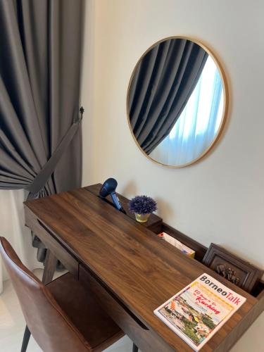 a wooden table with a mirror on a wall at LoFF Suite River View 2 Bedroom at Kuching Riverine Resort in Kuching