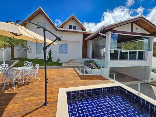 a house with a deck with a table and chairs at MANSÃO Casablanca in Nova Lima
