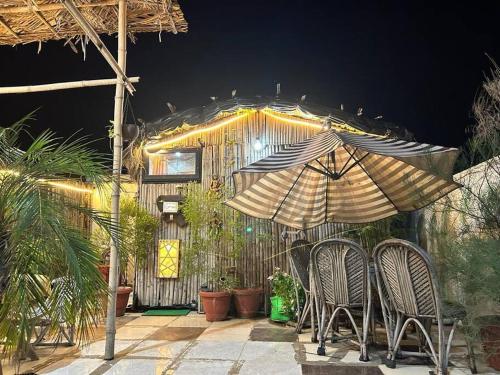 a patio with two chairs and an umbrella at 3BHK floor in urban homestay-swiming pool, Jacuzzi in Zirakpur