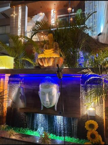 a statue of a head and a fountain in a room at 3BHK floor in urban homestay-swiming pool, Jacuzzi in Zirakpur