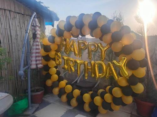 a balloon arch with a happy birthday sign on it at 3BHK floor in urban homestay-swiming pool, Jacuzzi in Zirakpur