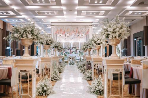 a wedding banquet hall with tables and chairs at Eastparc Hotel Yogyakarta in Yogyakarta