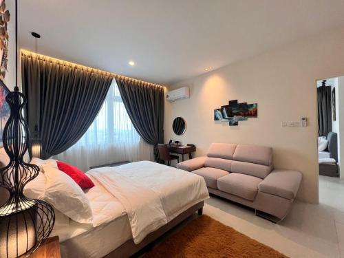 a bedroom with a bed and a couch at LoFF Suite River View 2 Bedroom at Kuching Riverine Resort in Kuching