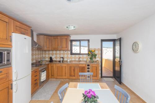 a kitchen with a table and a white refrigerator at Moya Rooftop House - 3BR in Moya