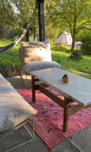a table and a chair sitting on a rug with a table and a cup at Design Cabin & Panorama Sauna in Várvölgy