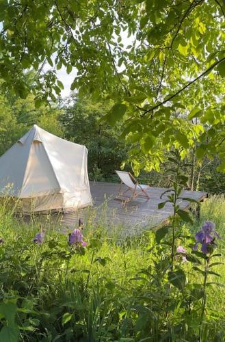 a white tent and a chair in a garden at Design Cabin & Panorama Sauna in Várvölgy
