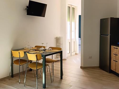a dining room with a table with chairs and a refrigerator at Attico 28 in Lecce