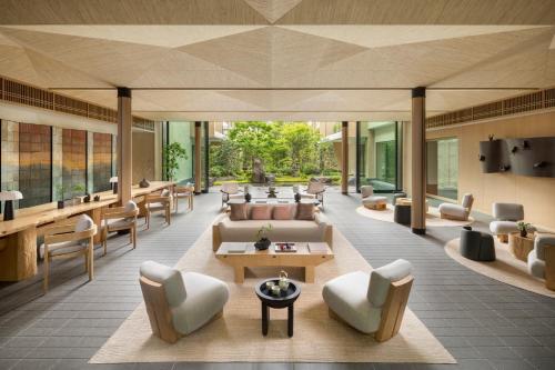 a lobby of a hotel with couches and chairs at Six Senses Kyoto in Kyoto