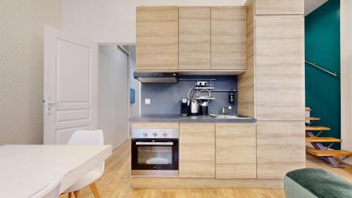 une cuisine avec des armoires en bois et un évier dans l'établissement Bluestay 4 - Superbe appartement à Paris, à Paris