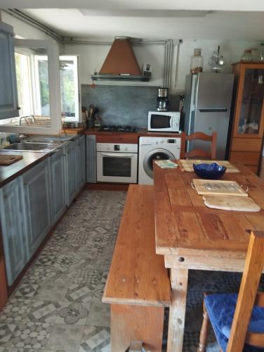 une cuisine avec une table en bois et un réfrigérateur dans l'établissement Chambre d'hôte partine cap Corse, à Santa-Maria-di-Lota