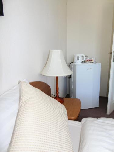 a bedroom with a bed with a lamp and a refrigerator at Toris Inn in Třinec