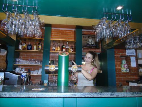 a woman standing at a bar making a drink at Toris Inn in Třinec