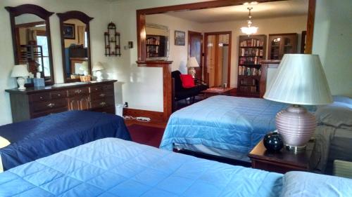 a bedroom with two beds and a lamp on a table at Fish & Loaves Bed and Breakfast in Numidia