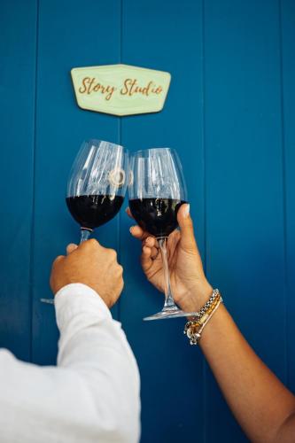 two people holding glasses of red wine at Story Studio Piódão - Heritage in Piódão
