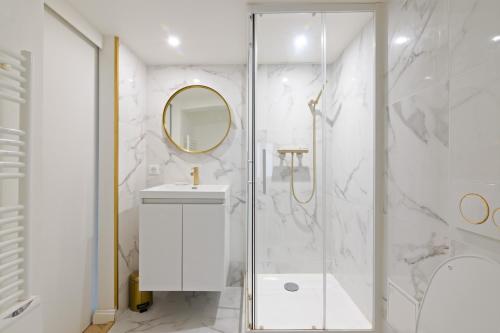 une salle de bain avec une douche, un lavabo et un miroir dans l'établissement Élégant Appartement près du Musée du Louvre et du Jardin des Tuileries Free Netflix, à Paris