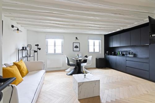 un salon avec un canapé blanc et une table dans l'établissement Élégant Appartement près du Musée du Louvre et du Jardin des Tuileries Free Netflix, à Paris