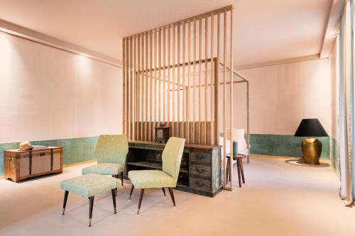 a room with a desk and chairs and a lamp at ASILO in BAROLO - The apartments in Barolo