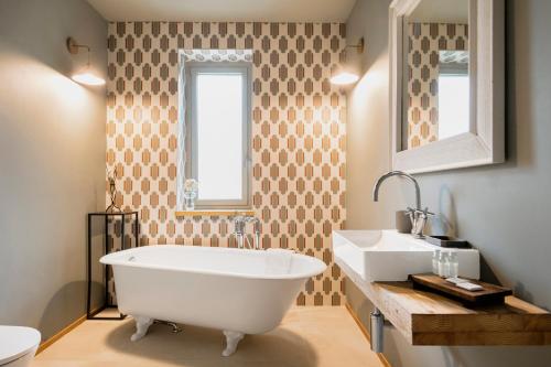 a bathroom with a white tub and a sink at ASILO in BAROLO - The apartments in Barolo