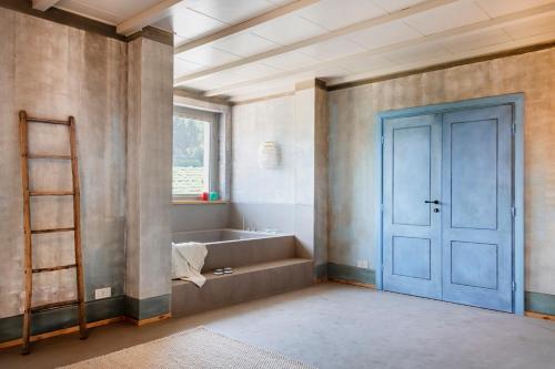 a bathroom with a blue door and a bath tub at ASILO in BAROLO - The apartments in Barolo