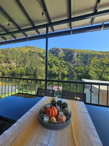 a bowl of pumpkins on a table with a view at Green Rock Cabin in Someşu Cald