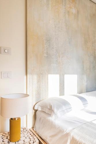 a bedroom with a bed and a table with a lamp at ASILO in BAROLO - The apartments in Barolo
