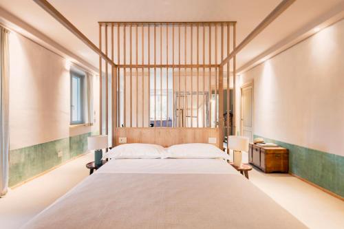 a large bedroom with a large bed and two lamps at ASILO in BAROLO - The apartments in Barolo
