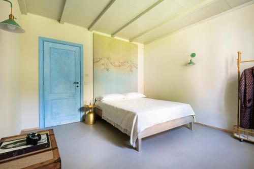 a bedroom with a bed and a blue door at ASILO in BAROLO - The apartments in Barolo