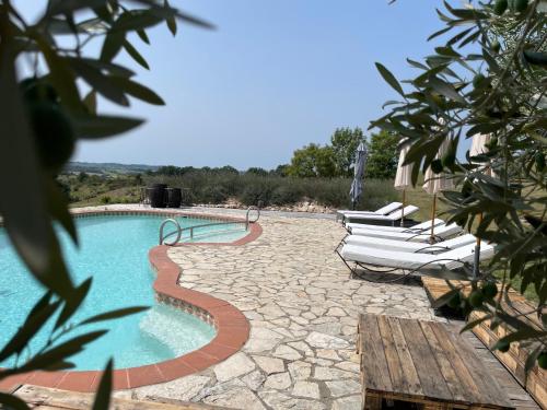 une piscine avec des chaises longues à côté dans l'établissement Ferme domaine de Maurel, à Le Fossat