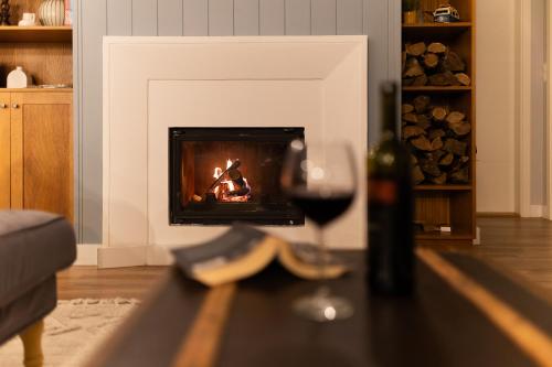 a glass of wine sitting on a table in front of a fireplace at Otthon Földváron in Balatonföldvár