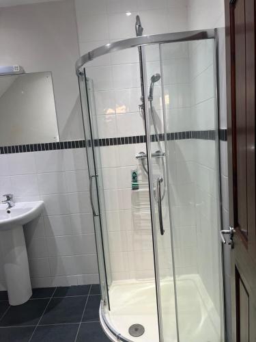 a shower with a glass door in a bathroom at Self contain studio with room, double bed, kitchen in London
