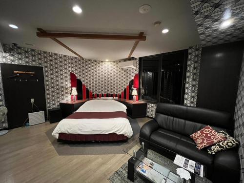 a large bedroom with a bed and a couch at オーラリゾート四條畷 in Shijonawate