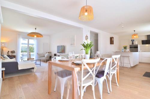 une salle à manger et un salon avec une table et des chaises dans l'établissement Kerlaouen - Maison avec jardin et spa - 5 min plage Carnac, à Carnac